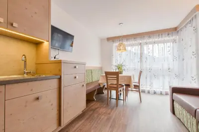 a kitchen and dining room with a table and chairs at Apartments Ciasa Costa in Badia
