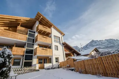 a house in the snow with a fence at Apartments Ciasa Costa in Badia