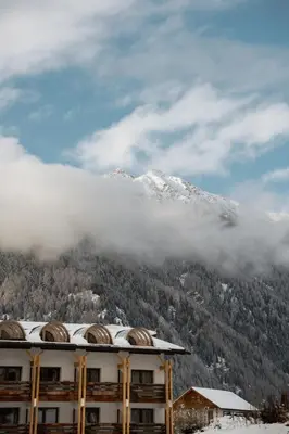 a building with a snow covered mountain in the background at Hotel Valserhof in Valles