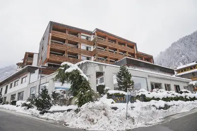 a large building with snow in front of it at Hotel Valserhof in Valles
