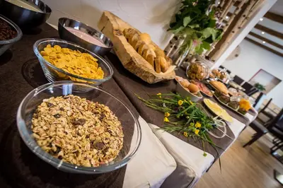 a table topped with bowls of food and bread at Hotel La Sorgente in Tesero