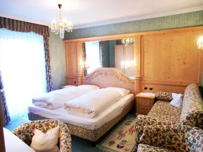 a bedroom with two beds and a couch at Pension Panorama in San Lorenzo di Sebato