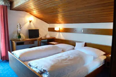 a bedroom with two beds and a television in it at Pension Panorama in San Lorenzo di Sebato