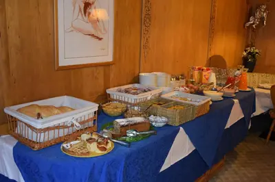a table with baskets of food and bread on it at Hotel Alpenrose in Alleghe