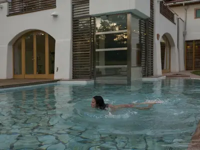 a woman swimming in a swimming pool in a house at Castelir Suite Hotel in Panchia