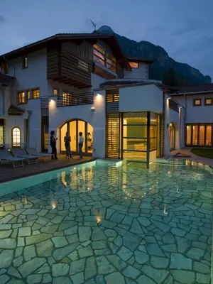 a house with a swimming pool in front of a house at Castelir Suite Hotel in Panchia