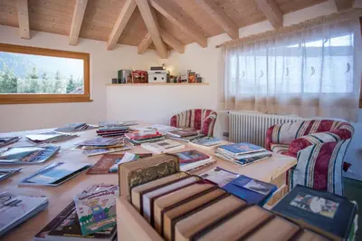a large wooden table with books on it in a room at Castelir Suite Hotel in Panchia