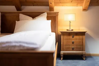 a bedroom with a bed and a lamp on a nightstand at Die Villa bei Meran in Marlengo