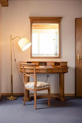 a desk with a chair and a lamp and a window at Die Villa bei Meran in Marlengo