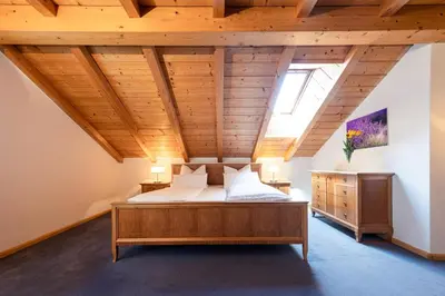 a bedroom with a bed and a wooden ceiling at Die Villa bei Meran in Marlengo
