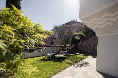 a yard with two chairs and a swimming pool at Die Villa bei Meran in Marlengo