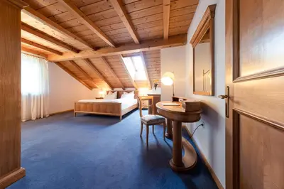a bedroom with a bed and a desk in a room at Die Villa bei Meran in Marlengo