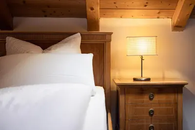a bedroom with a bed and a lamp on a night stand at Die Villa bei Meran in Marlengo