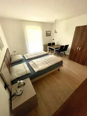 a bedroom with a bed and a table and a dining room at Gutshof Erschbaumer in San Lorenzo di Sebato