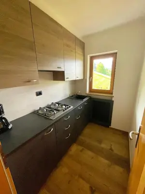 a kitchen with a stove and a window at Gutshof Erschbaumer in San Lorenzo di Sebato
