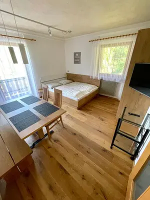 a bedroom with a bed and a table in a room at Gutshof Erschbaumer in San Lorenzo di Sebato