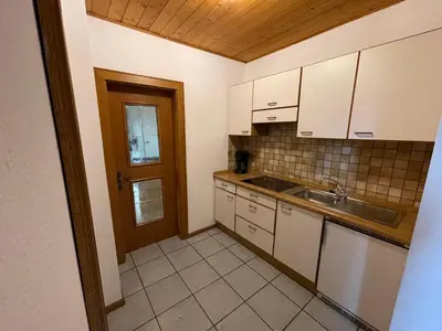 a kitchen with white cabinets and a sink at Gutshof Erschbaumer in San Lorenzo di Sebato