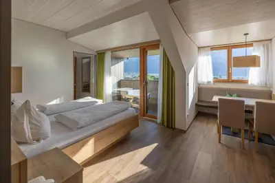 a bedroom with a bed and a table and chairs at Residence Egger in Terlano