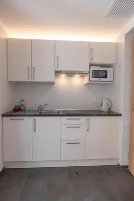 a kitchen with white cabinets and a microwave at Residence Egger in Terlano