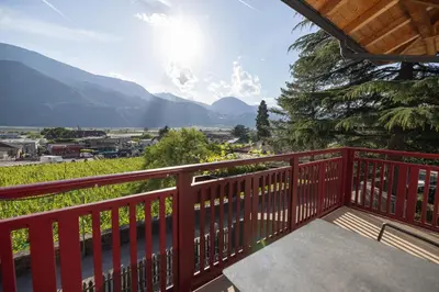 a red balcony with a view of mountains at Residence Egger in Terlano