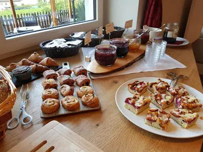 a table topped with plates of pastries and other desserts at Residence Egger in Terlano