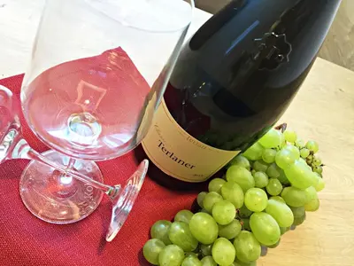 a bottle of wine and a bunch of grapes at Residence Egger in Terlano