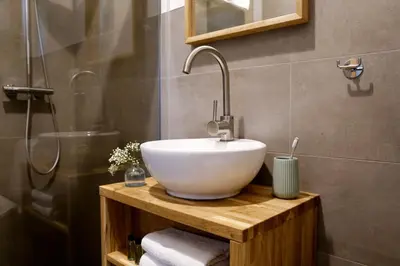 a bathroom with a white sink and a shower at Julias Guesthouse in Ora/Auer