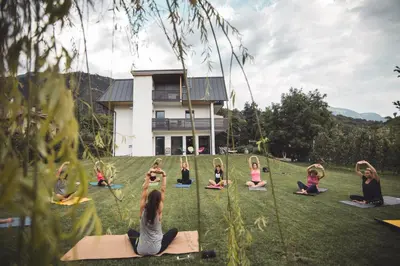 a group of people sitting in a field doing yoga at Julias Guesthouse in Ora/Auer