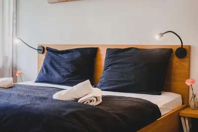 a bedroom with two beds with blue pillows at Julias Guesthouse in Ora/Auer