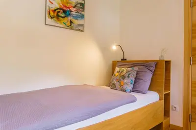a bedroom with a bed with purple sheets and a pillow at Julias Guesthouse in Ora/Auer