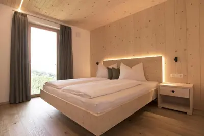 a bedroom with a large bed and a window at Greiterhof in Lana
