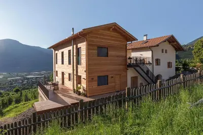 a house on top of a hill with a fence at Greiterhof in Lana