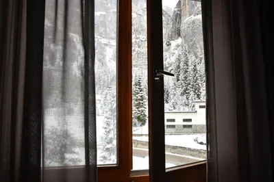 a window with a view of a snow covered mountain at Hotel Principe Marmolada in Malga Ciapela