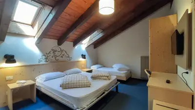 a bedroom with two beds in a room at Hotel Principe Marmolada in Malga Ciapela