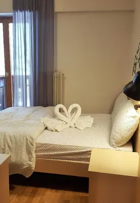 a bed with two white bows on top of it at Hotel Principe Marmolada in Malga Ciapela
