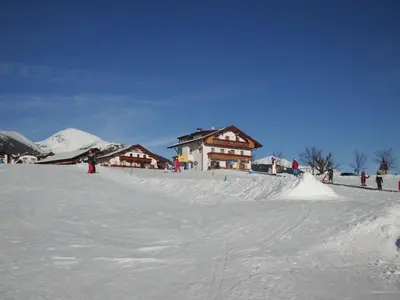 a group of people in the snow in front of buildings at Rosenheim in Maranza