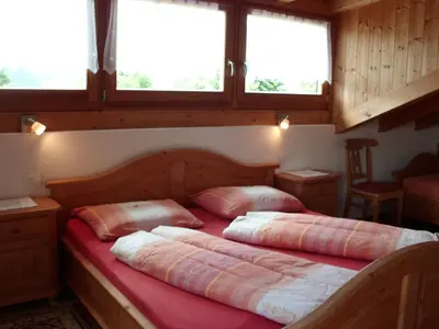 two beds in a room with two windows at Rosenheim in Maranza