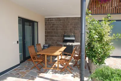 a patio with a wooden table and chairs at Weingut Messnerhof in Bolzano