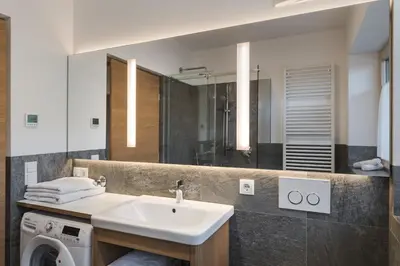 a bathroom with a sink and a washing machine at Weingut Messnerhof in Bolzano