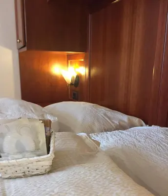 a bedroom with two beds and two chairs at Hotel Moena in Moena