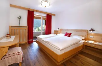 a bedroom with a large bed and a window at Apartments Victoria in Ortisei