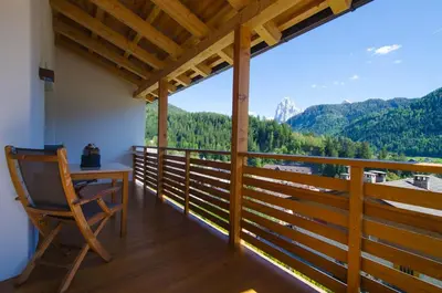 a room with a desk and a chair on a balcony at Apartments Victoria in Ortisei