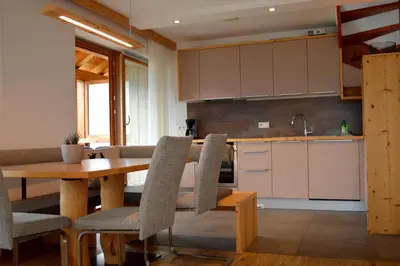 a kitchen with a wooden table and chairs in a room at Hintnerhof in Chiusa