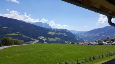 a view of a green field with mountains in the background at Hintnerhof in Chiusa