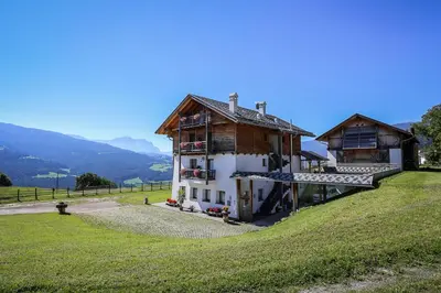a house on top of a grassy hill at Hintnerhof in Chiusa