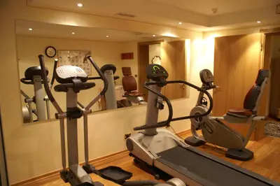 a gym with a treadmill and a mirror at Hotel Sittnerhof in Merano