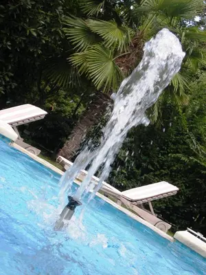 a fountain in the middle of a swimming pool at Hotel Sittnerhof in Merano