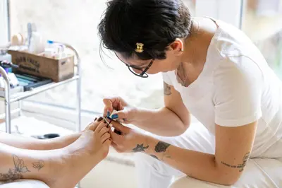 a woman getting a tattoo on her foot at Hotel Sittnerhof in Merano