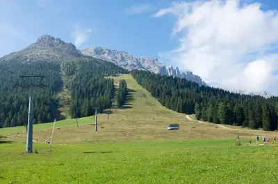 a man and a woman sitting on top of a mountain at Apartment Mansarda Carezza in Carezza al Lago