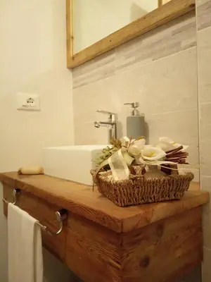 a bathroom with a sink and a basket on a counter at Da Valentina in Castelfondo
